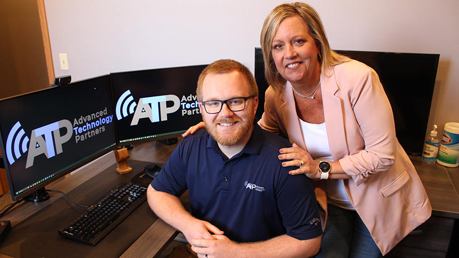 Michelle and justin smiling at desk